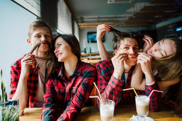 Grup genç arkadaşlar bir kahve dükkanında dışarı asılı. Genç erkek ve kadınların bir kafede kahve içme ve eğlenmek tanışmak. Yaşam tarzı, dostluk ve kentsel yaşam kavramları.