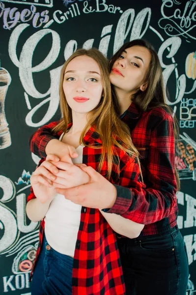 Un grupo de jóvenes amigos pasando el rato en una cafetería. Hombres y mujeres jóvenes que se reúnen en un café divirtiéndose y tomando café. Conceptos de estilo de vida, amistad y vida urbana . —  Fotos de Stock