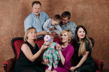 Üç nesil aile birlikte kanepede oturuyor. Klasik portre