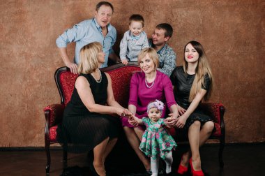 Üç nesil aile birlikte kanepede oturuyor. Klasik portre