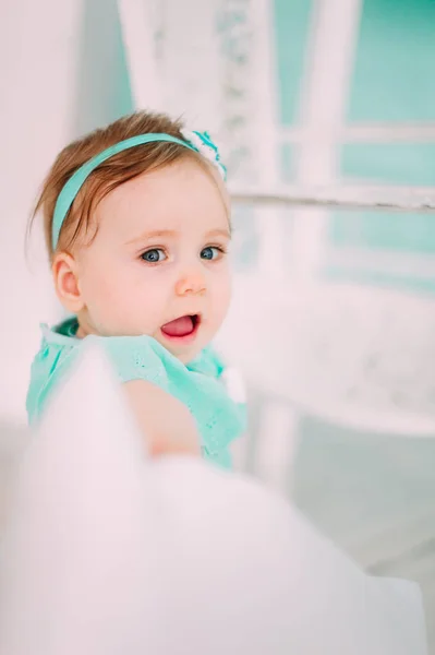 Adorable niña riéndose, sonriendo, arrastrándose y jugando en el estudio con vestido de menta — Foto de Stock