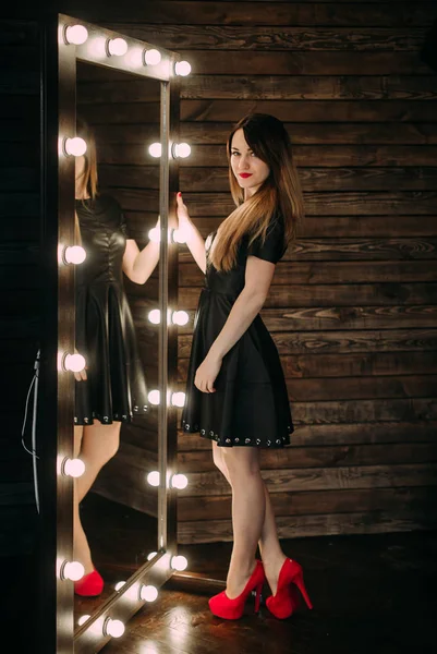 Portrait of a beautiful woman  near a mirror. — Stock Photo, Image