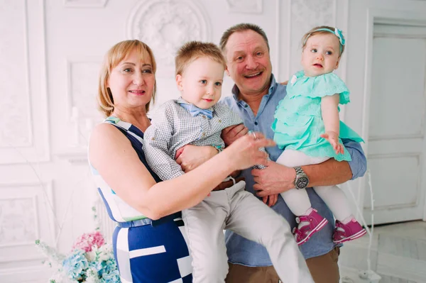 Grandchildren and grandparents in living room — Stock Photo, Image