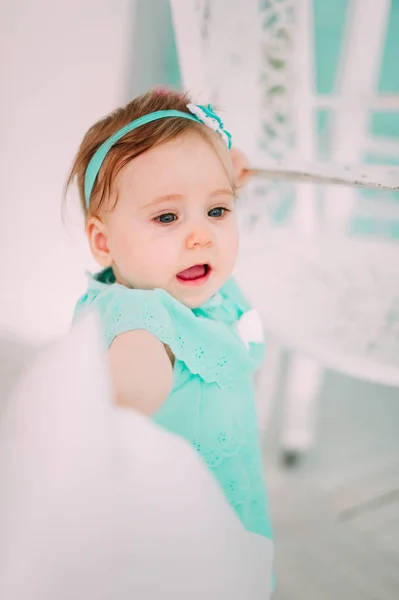 Adorável menina rindo, sorrindo, rastejando e brincando no estúdio vestindo vestido de hortelã — Fotografia de Stock