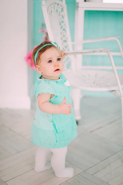 Adorable niña riéndose, sonriendo, arrastrándose y jugando en el estudio con vestido de menta — Foto de Stock