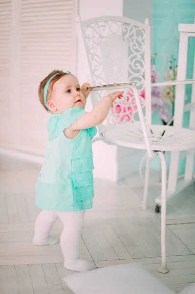 Adorable little dziewczynka, śmiejąc się, uśmiecha się, pełzanie & grając w studio sukience mięty — Zdjęcie stockowe
