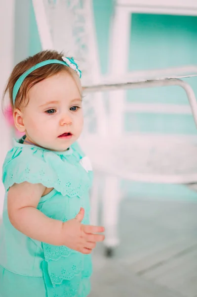 Gülen, gülümseyen, sürünen ve nane elbise stüdyoda oynayan sevimli küçük bebek kız — Stok fotoğraf