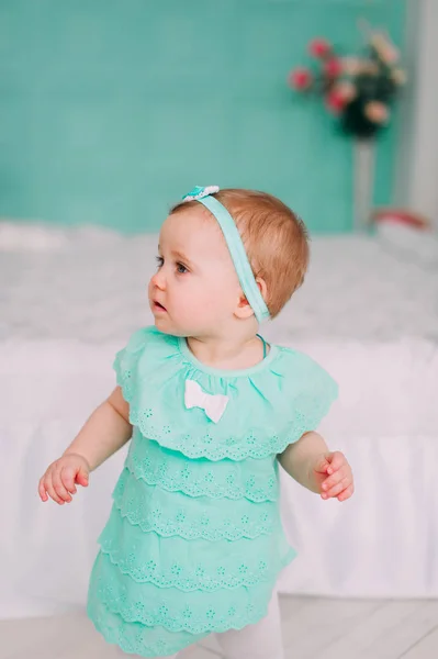 Bedårande liten flicka skrattar, ler, krypande & spela i studion bär mynta klänning — Stockfoto