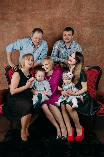 Üç nesil aile birlikte kanepede oturuyor. Klasik portre