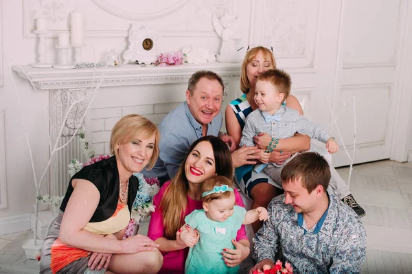 Uitgebreide familie ontspannen samen bij de open haard — Stockfoto