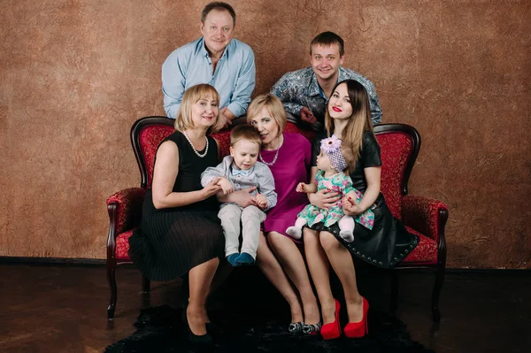 Familia de tres generaciones sentados en un sofá juntos. Retrato clásico — Foto de Stock