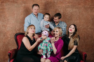 Üç nesil aile birlikte kanepede oturuyor. Klasik portre