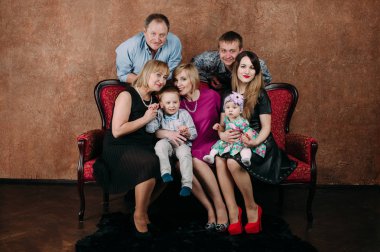 Üç nesil aile birlikte kanepede oturuyor. Klasik portre