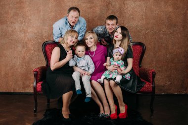 Üç nesil aile birlikte kanepede oturuyor. Klasik portre