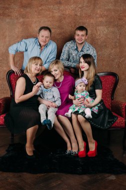 Üç nesil aile birlikte kanepede oturuyor. Klasik portre