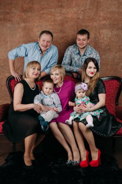 Üç nesil aile birlikte kanepede oturuyor. Klasik portre