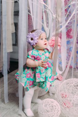 Gülen, gülümseyen, sürünen ve nane elbise stüdyoda oynayan sevimli küçük bebek kız