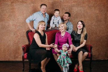 Üç nesil aile birlikte kanepede oturuyor. Klasik portre