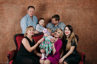 Üç nesil aile birlikte kanepede oturuyor. Klasik portre