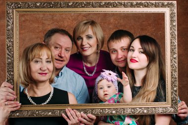 Üç nesil aile birlikte kanepede oturuyor. Klasik portre