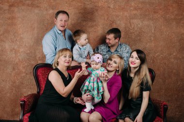 Üç nesil aile birlikte kanepede oturuyor. Klasik portre