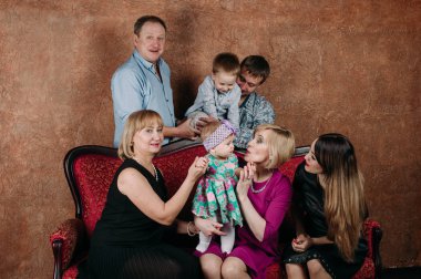 Üç nesil aile birlikte kanepede oturuyor. Klasik portre