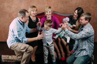 Üç nesil aile birlikte kanepede oturuyor. Klasik portre