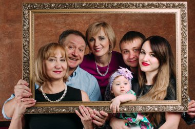 Üç nesil aile birlikte kanepede oturuyor. Klasik portre