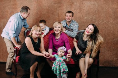 Üç nesil aile birlikte kanepede oturuyor. Klasik portre