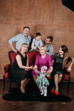 Üç nesil aile birlikte kanepede oturuyor. Klasik portre