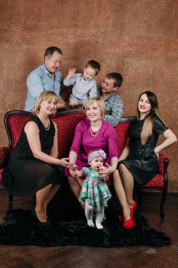 Üç nesil aile birlikte kanepede oturuyor. Klasik portre