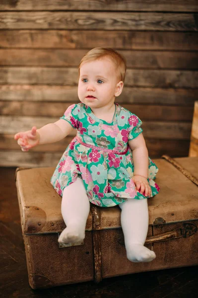 Adorável menina rindo, sorrindo, rastejando e brincando no estúdio vestindo vestido de hortelã — Fotografia de Stock