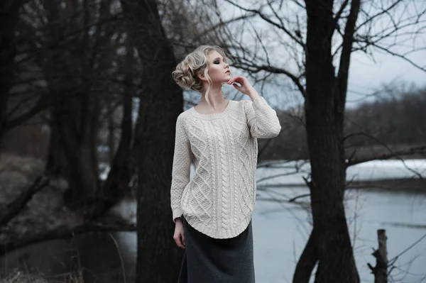 Piękna młoda kobieta Blondynka o niebieskich oczach, w długiej spódnicy biały sweter na tło wiosna, Las, jezioro, drzewa. Zimno nastroju. Moda, portret emocjonalne — Zdjęcie stockowe