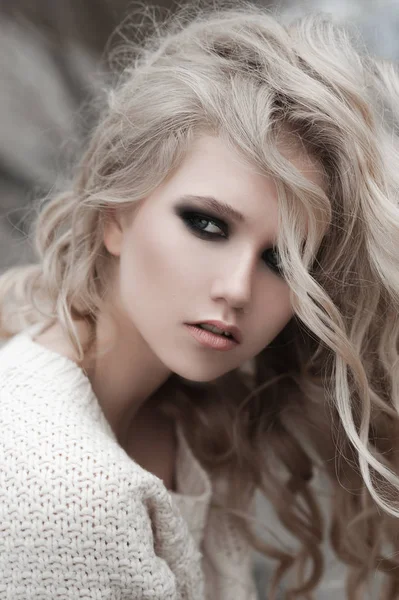 Primer plano de hermosa joven rubia con ojos azules en jersey blanco . — Foto de Stock