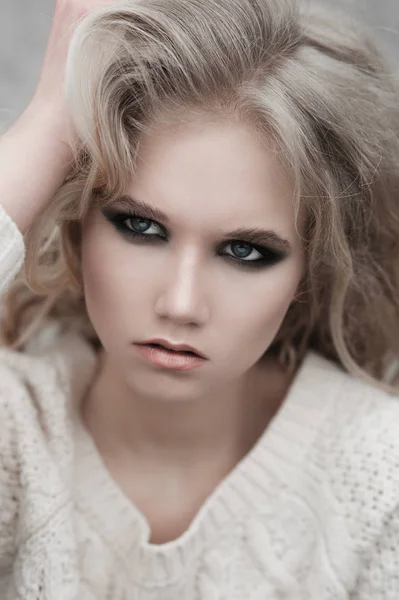 Szép fiatal szőke nő a fehér pulóver, kék szemmel közelről. — Stock Fotó