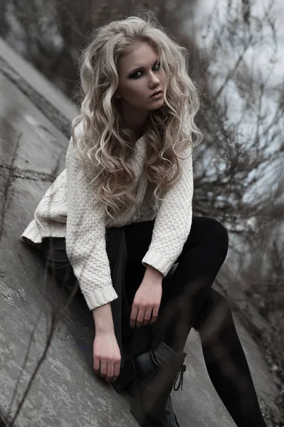 Mooie jonge blonde vrouw met blauwe ogen in de witte trui lange rok op voorjaar achtergrond, bomen, bos, lake. Koude sfeer. Mode, emotionele portret — Stockfoto