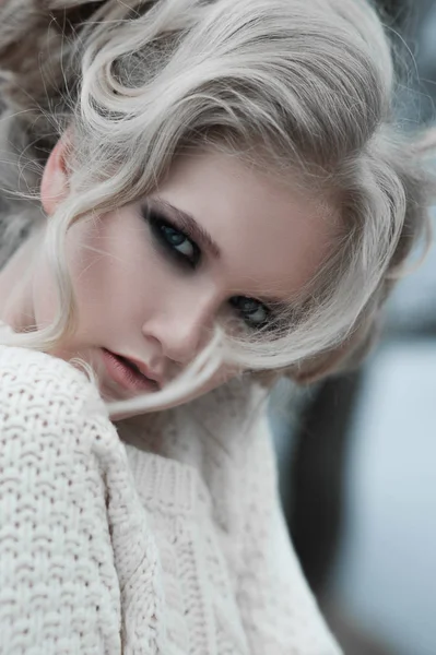 Close up of beautiful young  blonde woman with blue eyes in white pullover. — Stock Photo, Image