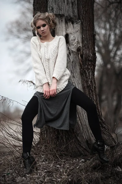 Hermosa mujer rubia joven con ojos azules en falda larga jersey blanco sobre fondo de primavera, bosque, lago, árboles. Humor frío. Moda, retrato emocional — Foto de Stock