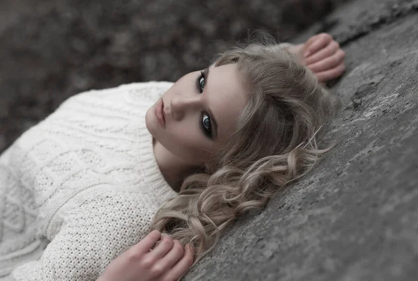 Zblízka krásná mladá blondýnka s modrýma očima v bílý svetr. — Stock fotografie