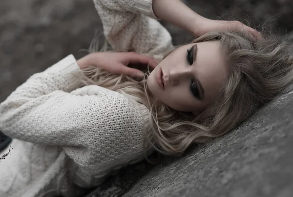 Όμορφη νεαρή ξανθιά γυναίκα με μπλε μάτια σε λευκό πουλόβερ σε κοντινό πλάνο. — Φωτογραφία Αρχείου