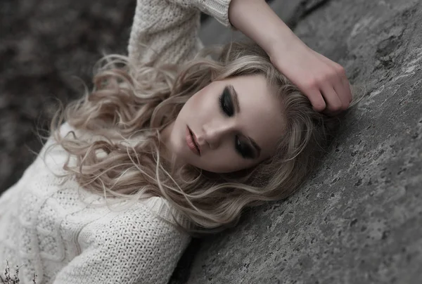 Zbliżenie na pięknej młodej kobiety Blondynka o niebieskich oczach w biały sweter. — Zdjęcie stockowe