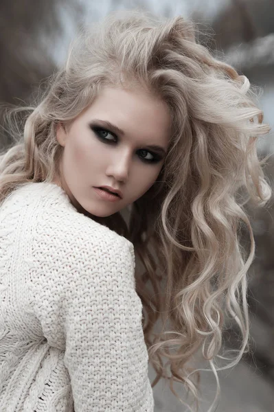 Όμορφη νεαρή ξανθιά γυναίκα με μπλε μάτια σε λευκό πουλόβερ σε κοντινό πλάνο. — Φωτογραφία Αρχείου