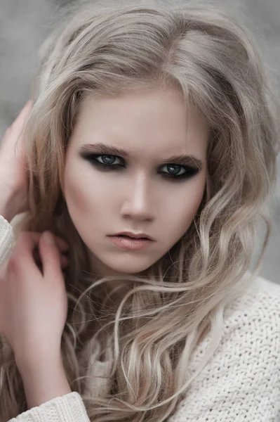 Close up of beautiful young  blonde woman with blue eyes in white pullover. Stock Picture