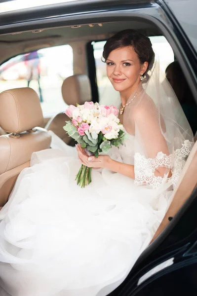 Svatební den. Sedí a usmíval se v autě s svatební nevěsta — Stock fotografie