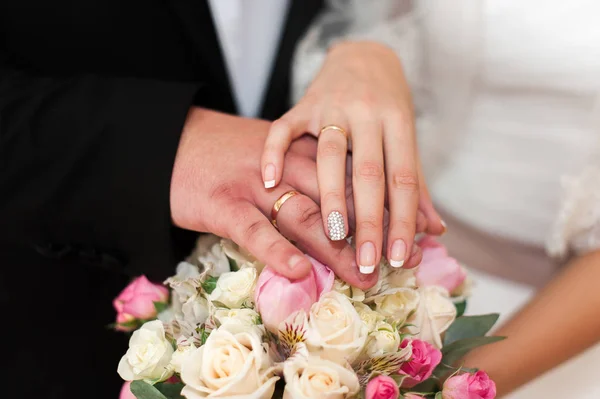 Mani di sposi con anelli su bouquet di nozze insoliti . — Foto Stock