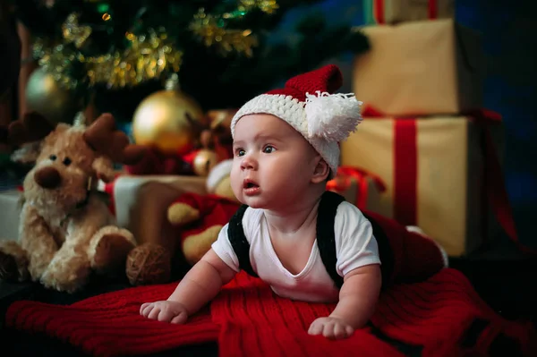 新年のコンセプトです。プレゼントとクリスマス ツリーの近くに愛らしい小さな少年。新しい年 — ストック写真