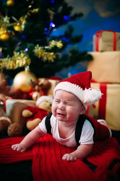 新年のコンセプトです。プレゼントとクリスマス ツリーの近くに愛らしい小さな少年。新しい年 — ストック写真