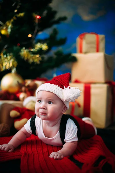 New Year's koncept. Bedårande liten pojke nära en julgran med presenter. nytt år — Stockfoto