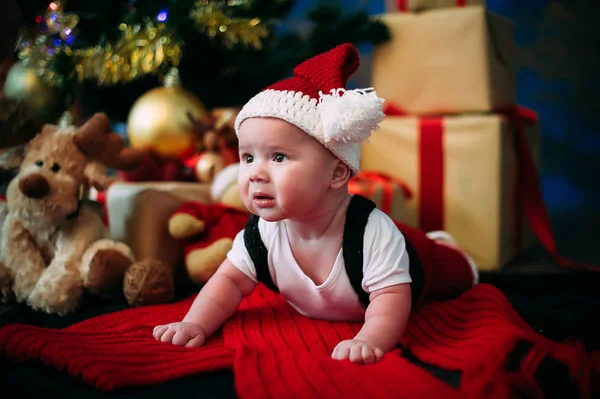 New Year's koncept. Bedårande liten pojke nära en julgran med presenter. nytt år — Stockfoto