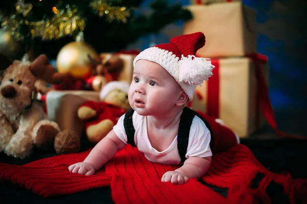 Concepto de Año Nuevo. Adorable niño pequeño cerca de un árbol de Navidad con regalos. año nuevo — Foto de Stock